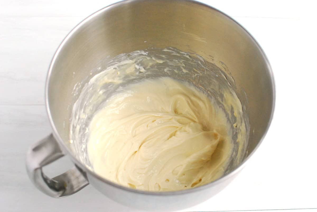 Cream cheese protein frosting in a silver mixing bowl.