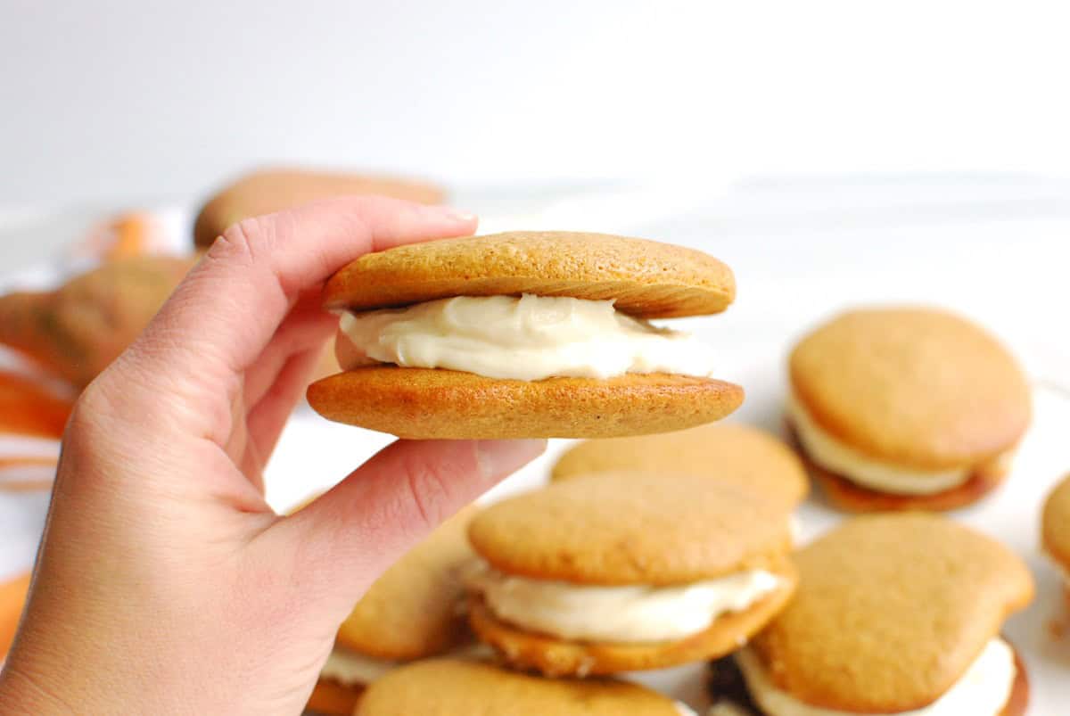 A woman's hand holding a sweetpotato protein whoopie pie.