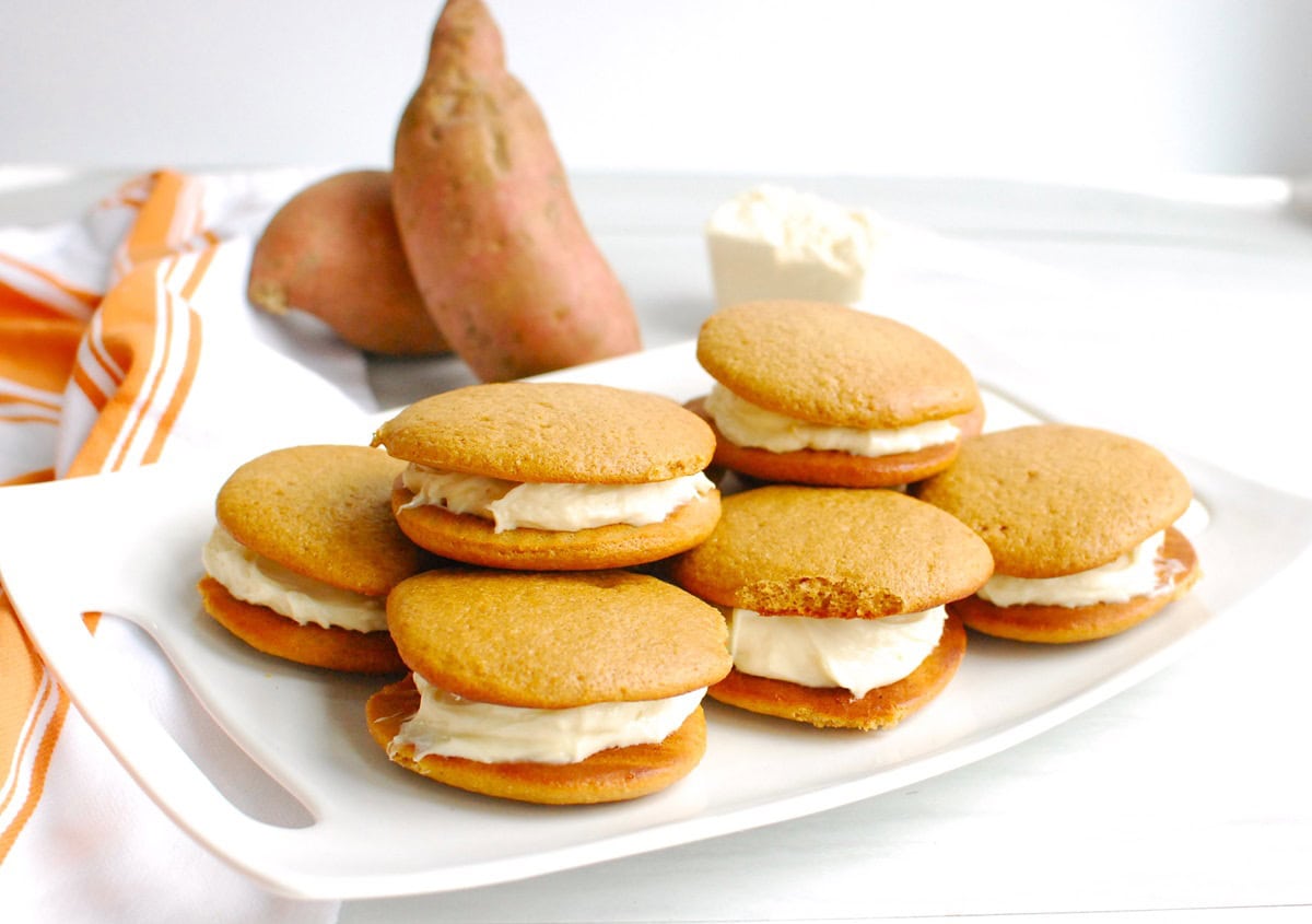A white platter with a bunch of protein sweetpotato whoopie pies.