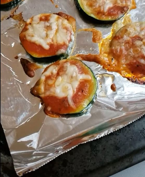 Zucchini pizza bites on a baking sheet.