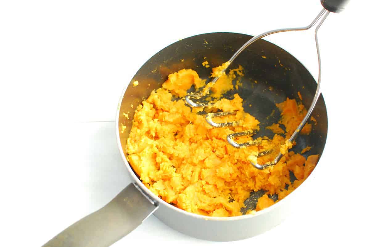 Mashed sweetpotatoes in a black pot.