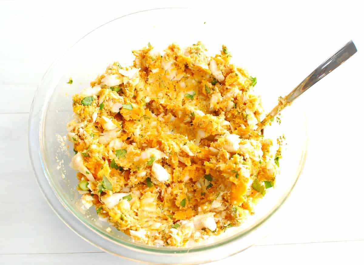 The fishcake ingredients mixed together in a glass mixing bowl.