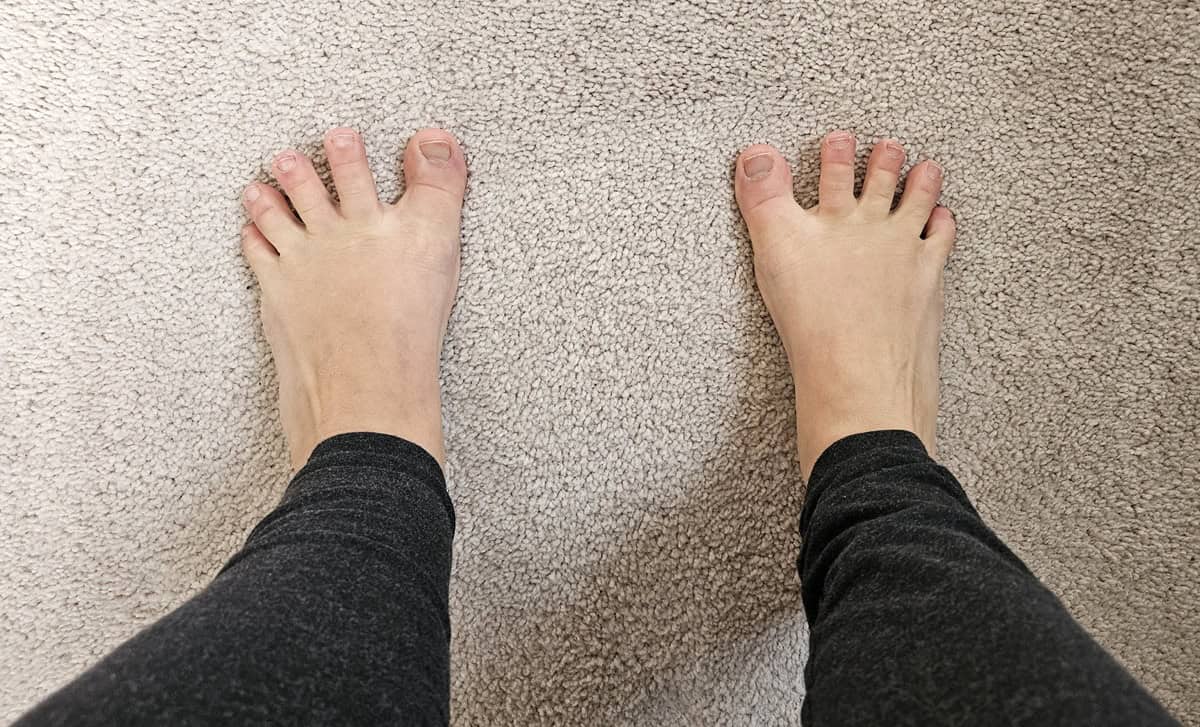 A woman's foot splaying her toes to stretch her foot.