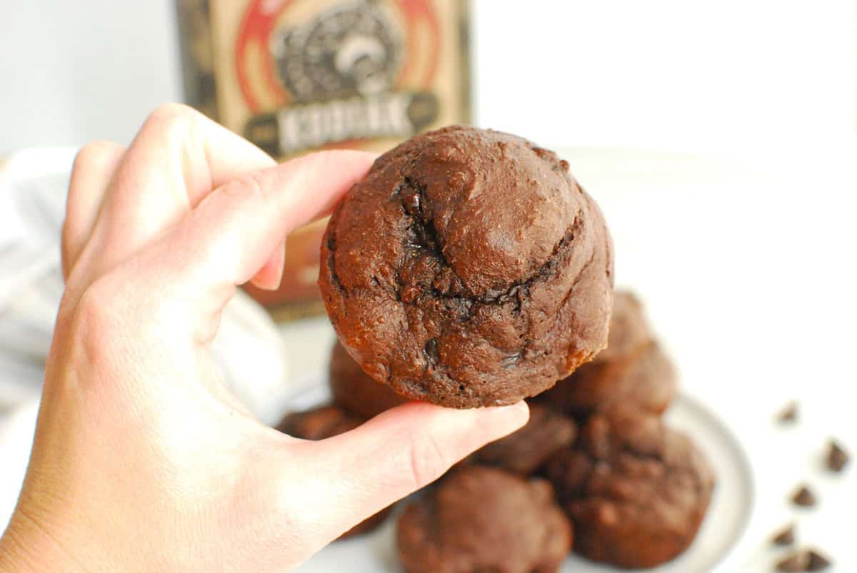 A woman's hand holding a Kodiak protein muffin.
