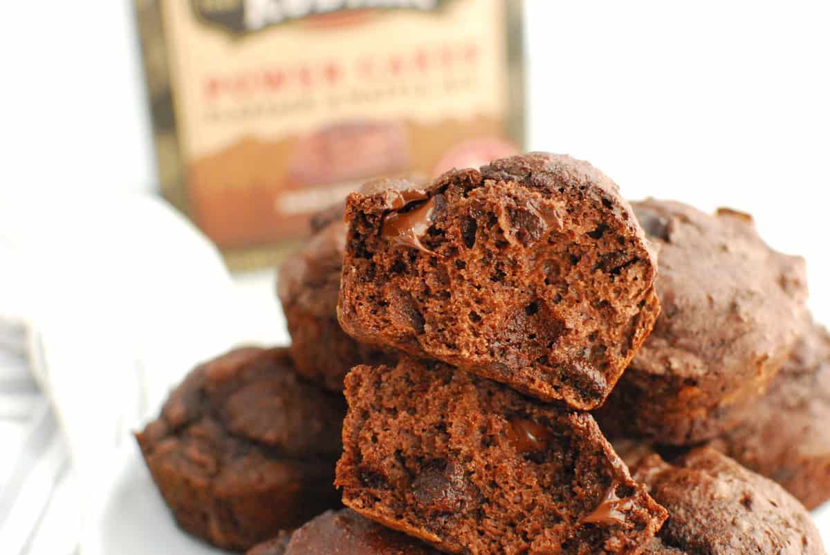 A chocolate protein muffin broken in half to show the texture on the inside.