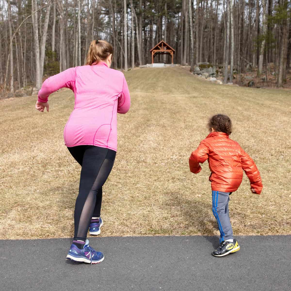 A woman and her kid doing a hill sprint running workout together.