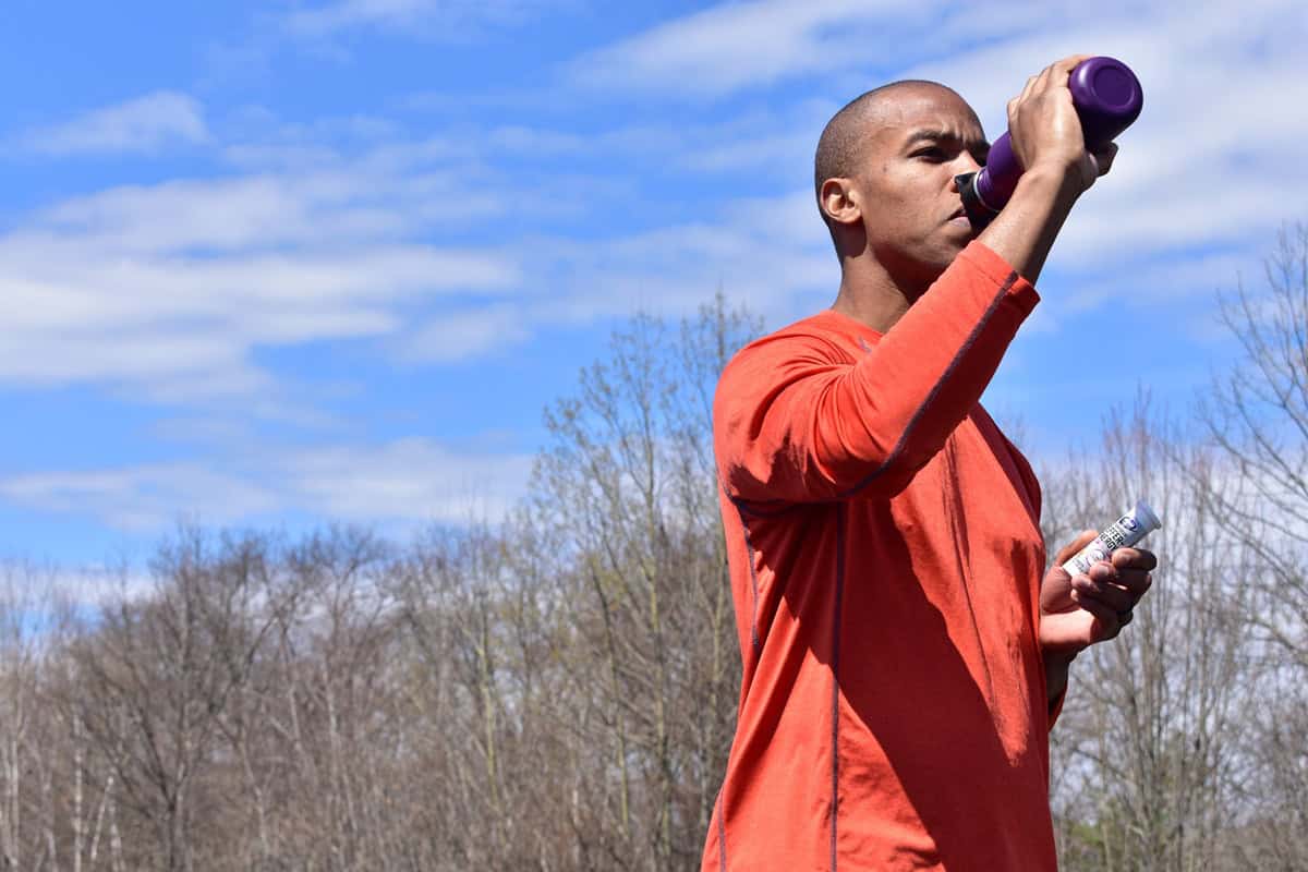 A man sipping on an electrolyte drink.