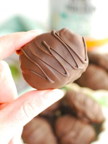 A woman's hand holding a healthy peanut butter egg.