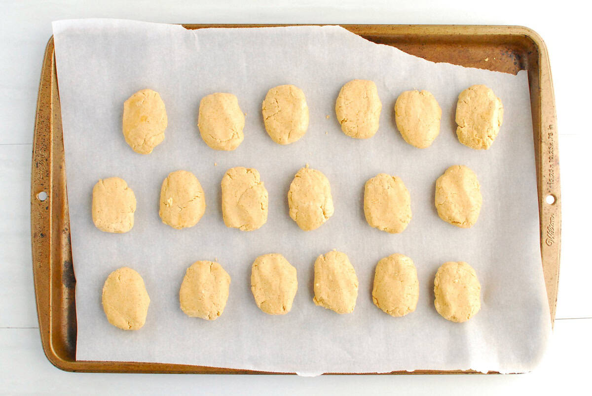 Peanut butter eggs on a parchment-lined baking sheet.
