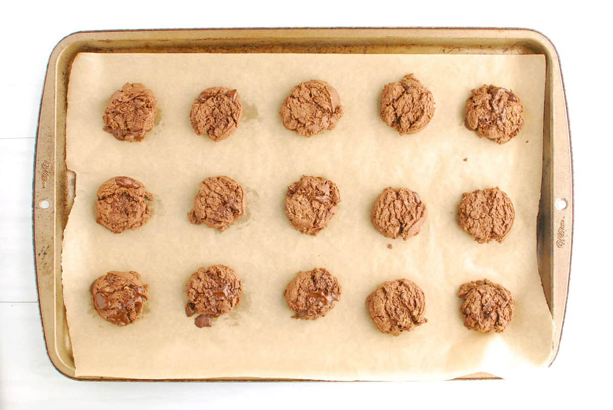 A baking sheet with just-baked chocolate cookies.