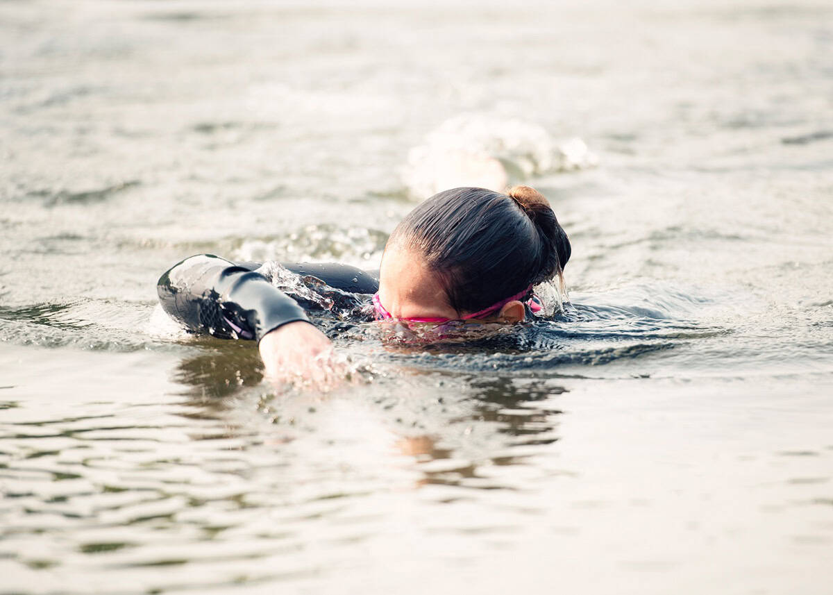 A woman swimming outside as a cross training activity.