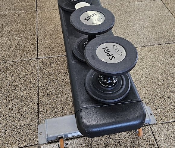 A set of weights on a bench depicting strength training.