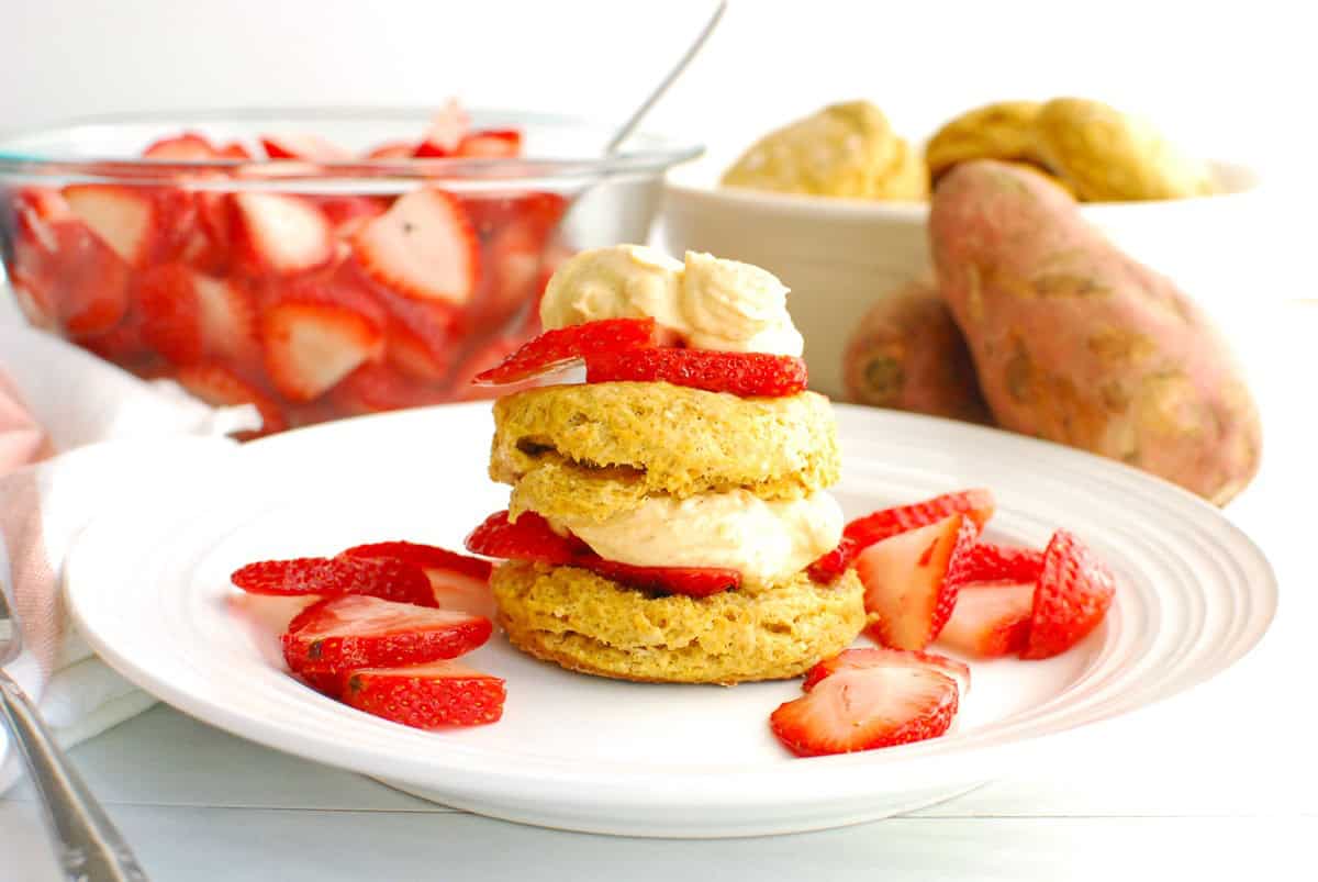 Strawberry shortcake with a sweetpotato biscuit on a white plate.