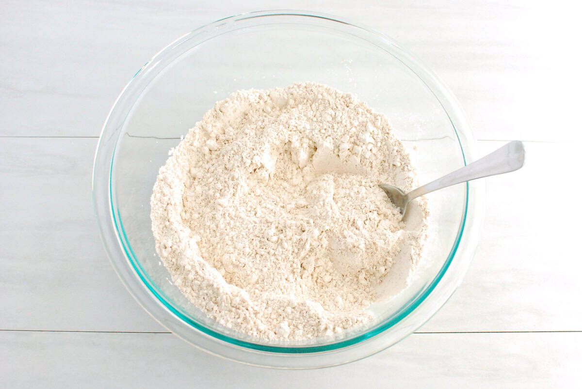 Flour, sugar, baking powder, cinnamon, and salt mixed together in a bowl.