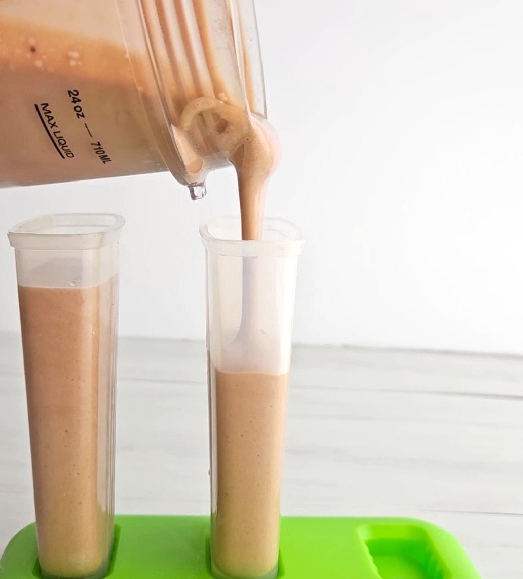 Pouring the ice pop mixture into popsicle molds.