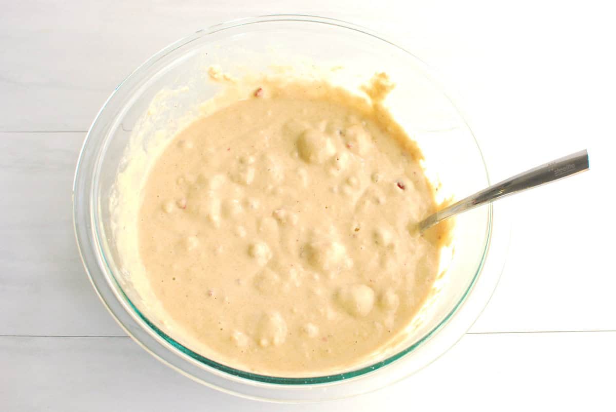 Raspberry protein muffin batter in a glass mixing bowl.