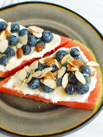 Two slices of watermelon ricotta pizza on a plate.