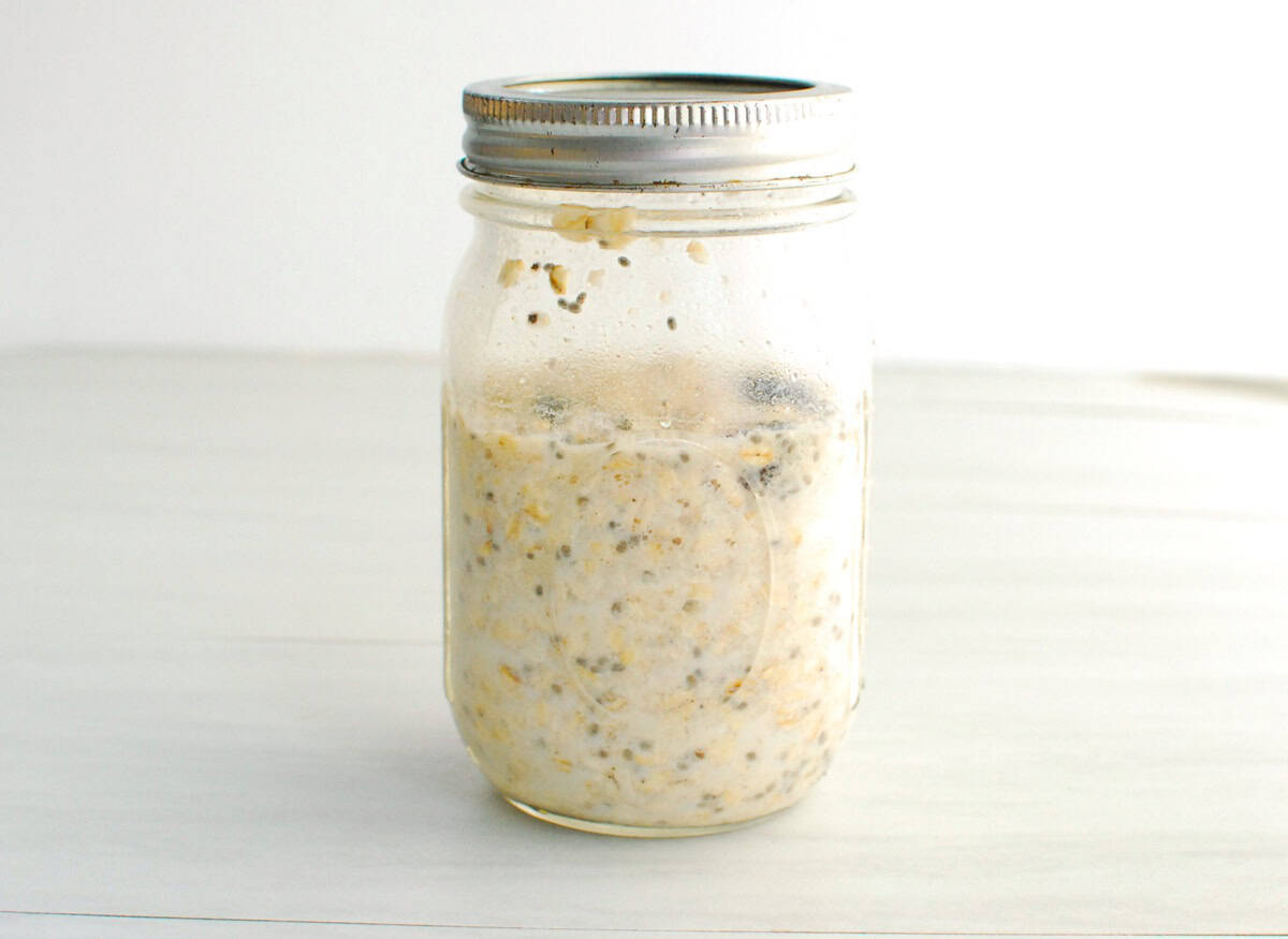 All of the ingredients for the overnight oats in a mason jar.