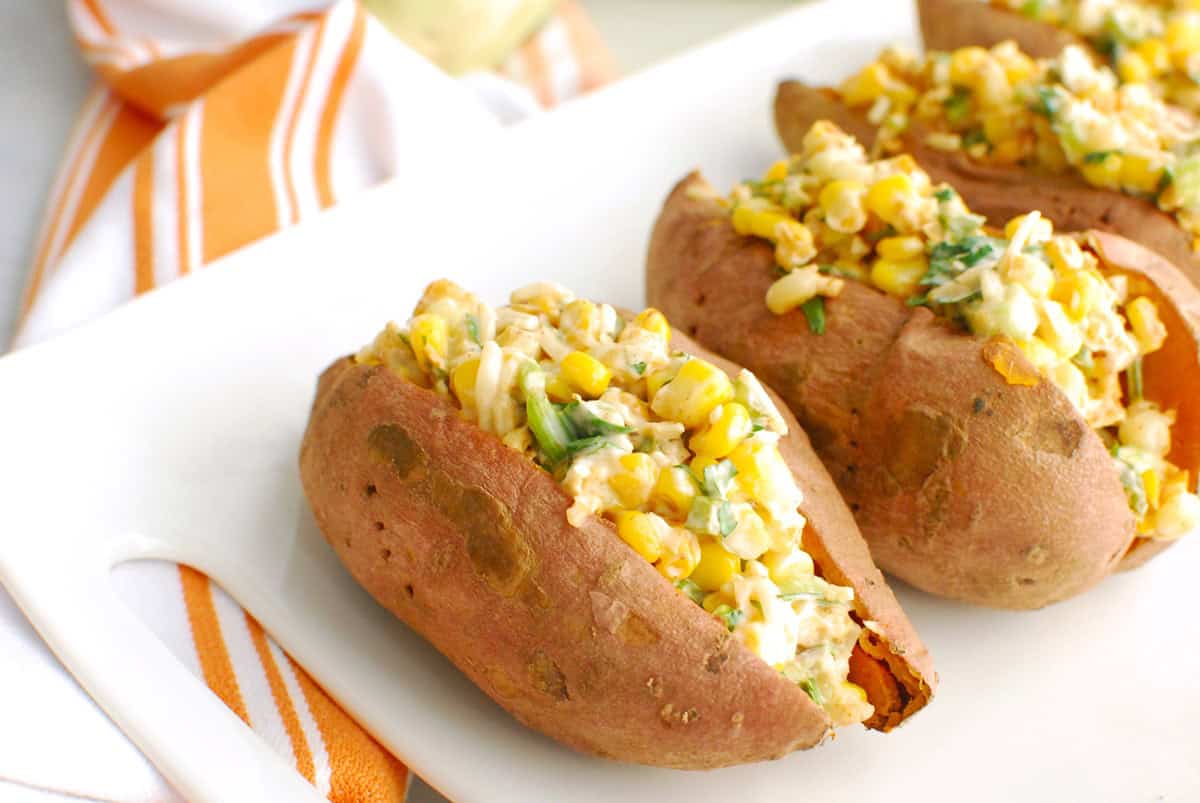 Street corn stuffed sweetpotatoes on a white platter.