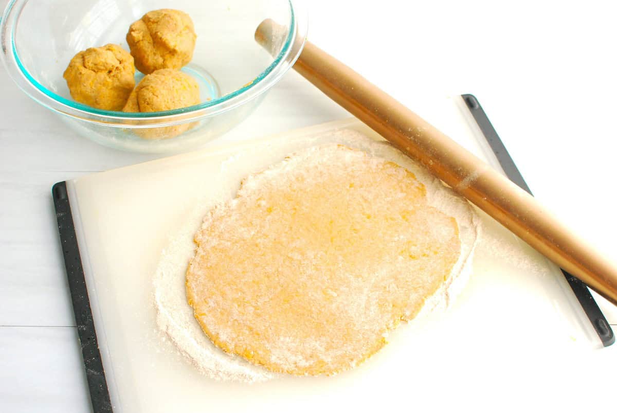 Flatbread dough rolled out on a floured surface.