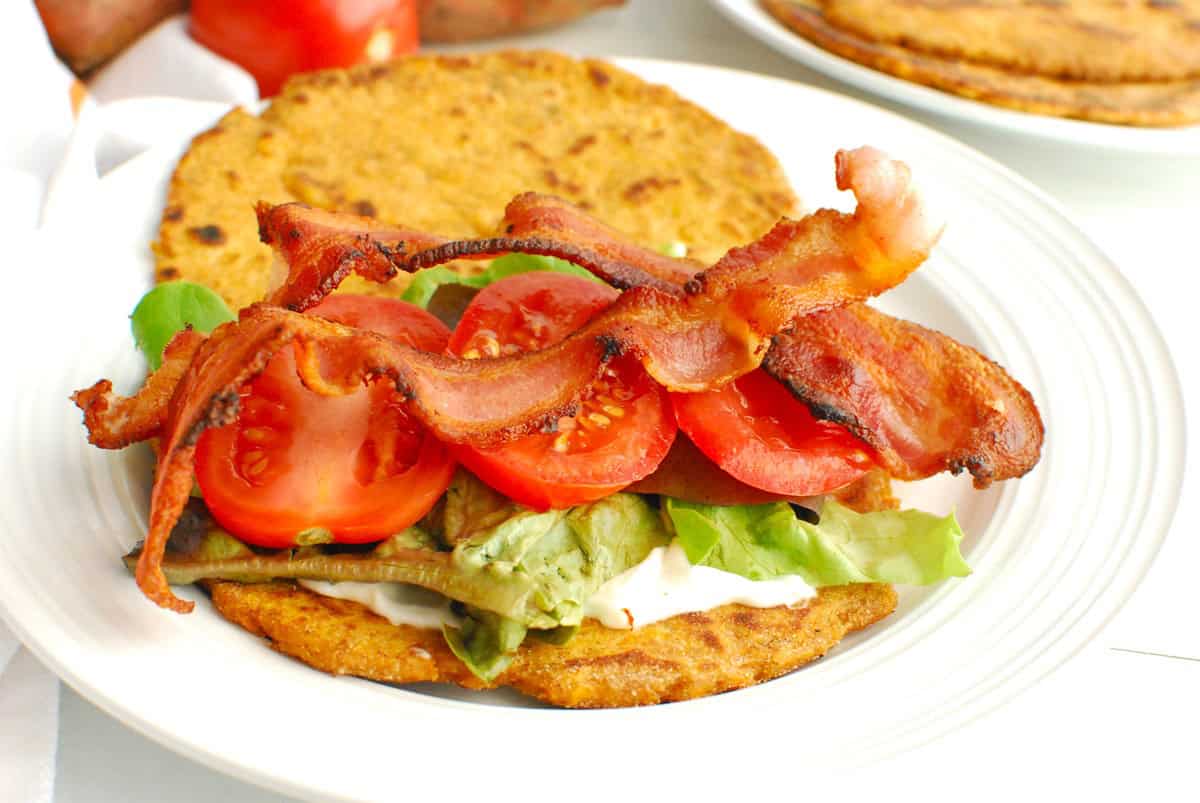 A sweetpotato flatbread topped with mayo, lettuce, bacon, and tomato.