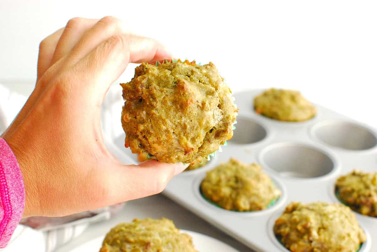 A woman's hand holding a high-protein cheeseburger muffin.