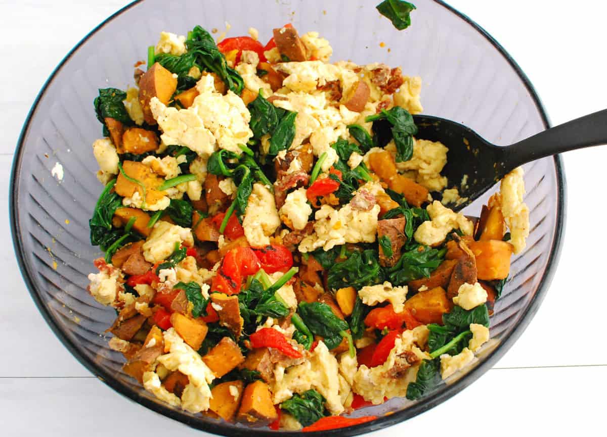 Breakfast burrito filling ingredients mixed together in a large bowl.