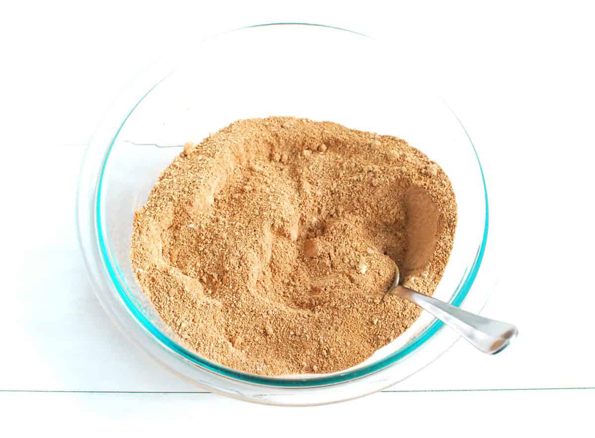 Almond flour, protein powder, cocoa powder, baking powder, and salt mixed together in a glass bowl.