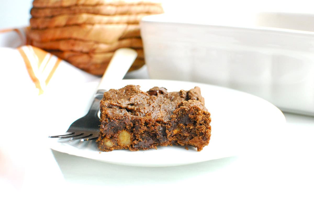 A pumpkin protein brownie on a plate with a fork next to it.