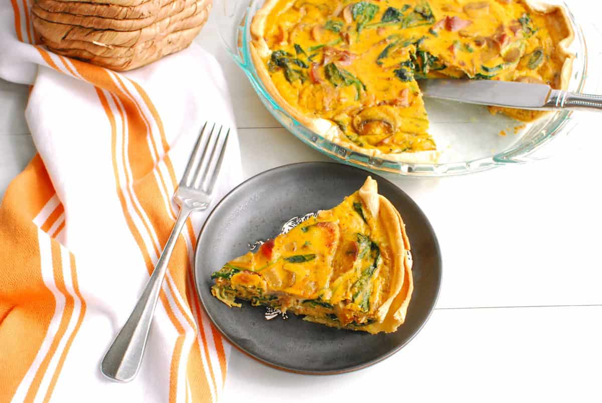 A slice of pumpkin quiche on a plate.