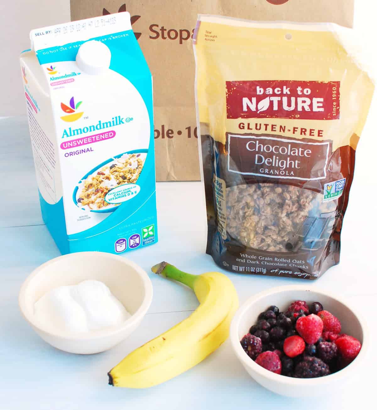 Granola, almond milk, yogurt, banana, and berries.