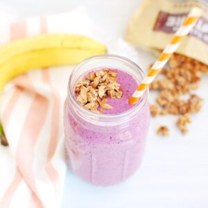 A berry banana granola smoothie in a mason jar.