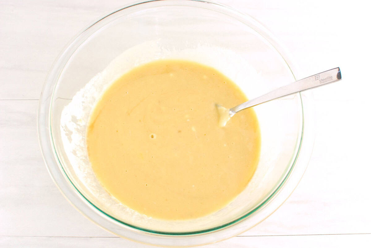 Yogurt, brown sugar, olive oil, eggs, and vanilla mixed together in a glass bowl.