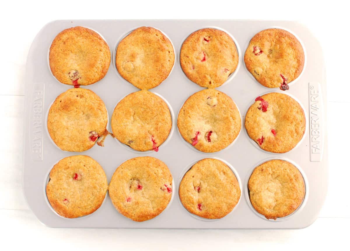 A muffin tin with just-baked cranberry protein muffins.