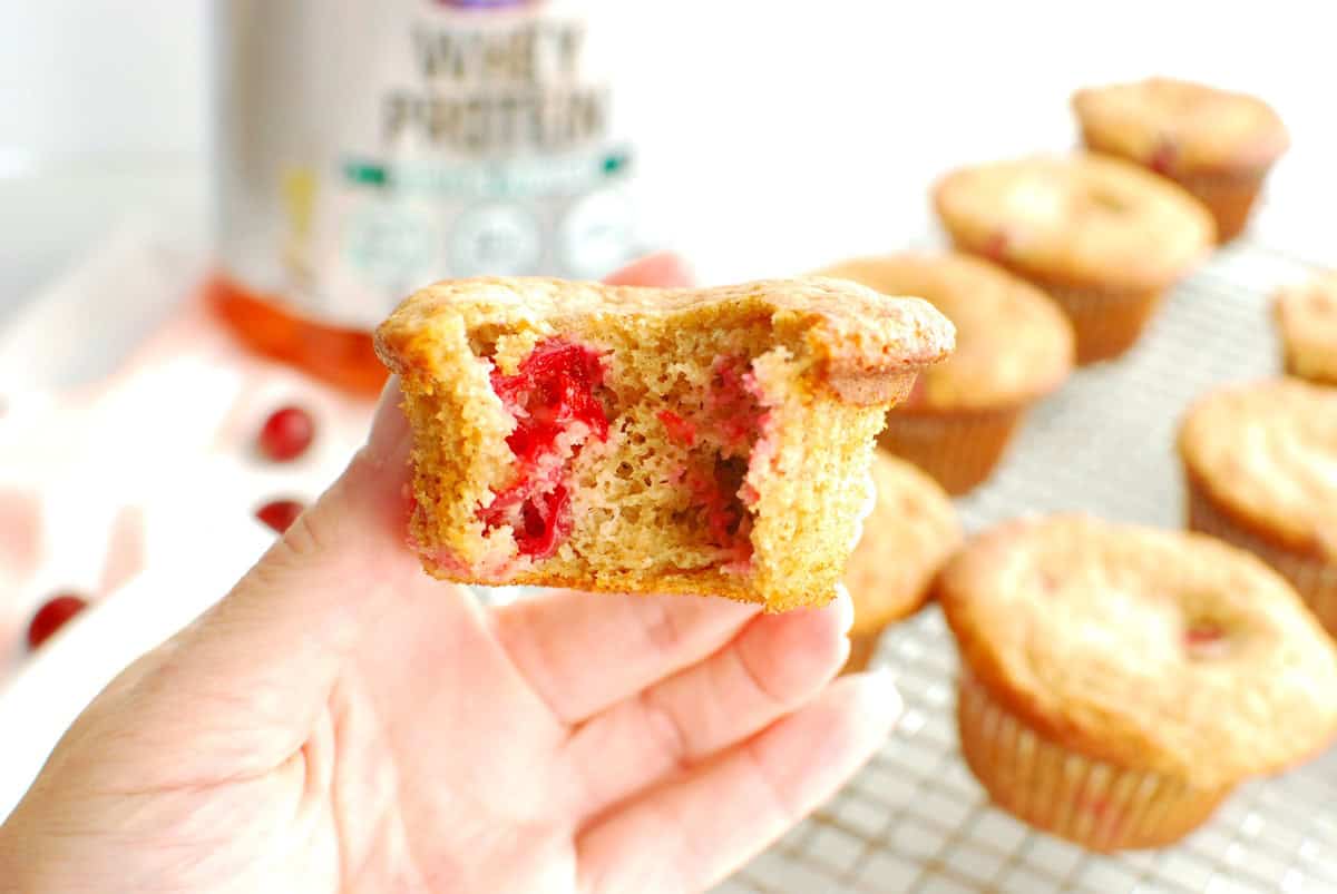 A cranberry protein muffin with a bite taken out of it.