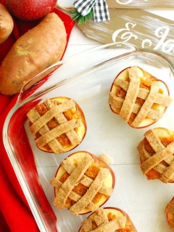 Several sweetpotato stuffed baked apples in a glass casserole dish.