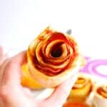 A woman's hand holding a pizza rose made with homemade dough.