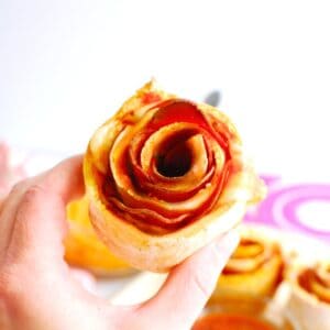 A woman's hand holding a pizza rose made with homemade dough.