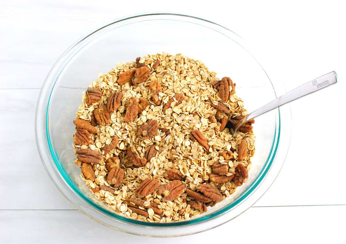 Oats, pecans, cinnamon, pumpkin spice, and salt combined in a glass mixing bowl.