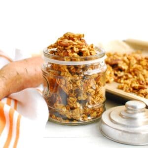 A glass jar filled with sweetpotato granola.