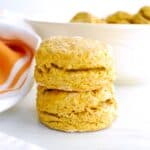 Two sweet potato biscuits on a white table with a napkin next to them.