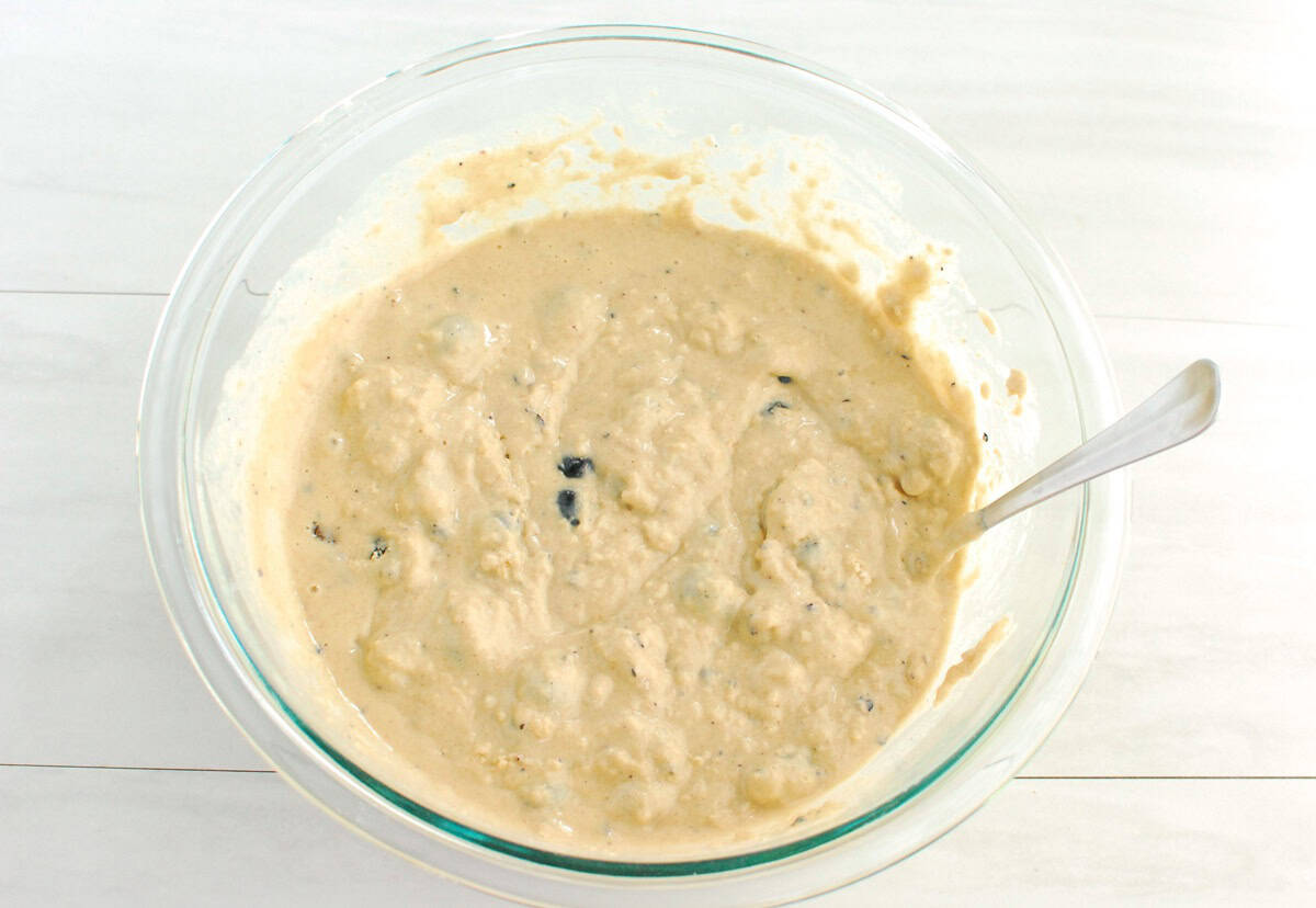 Blueberry muffin batter in a glass bowl.