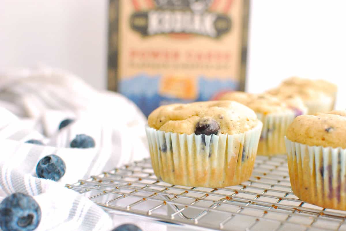 A Kodiak Cakes blueberry muffin on a cooling rack.