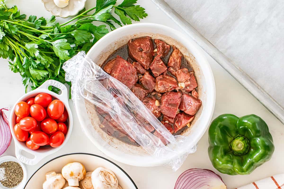 Steak in a bowl with the marinade.