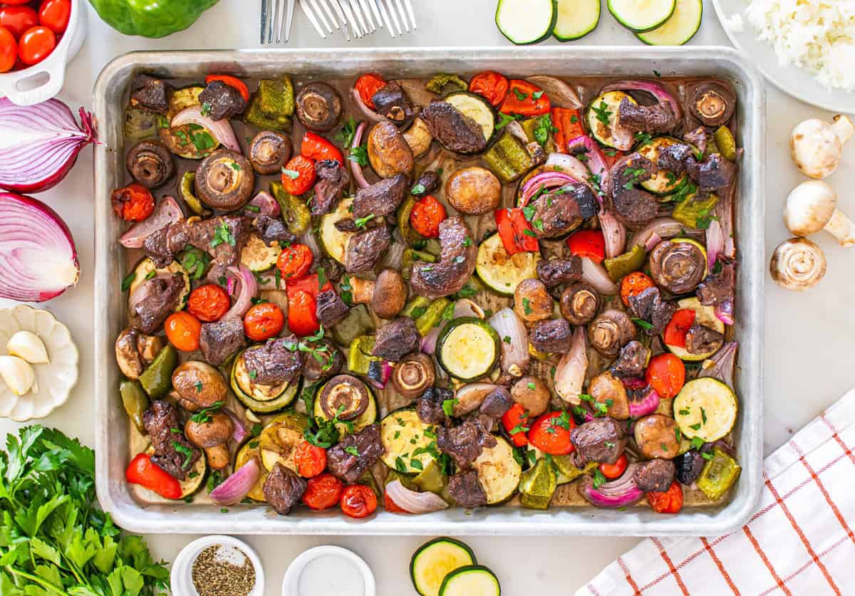 A sheet pan with just-roasted vegetables and steak.