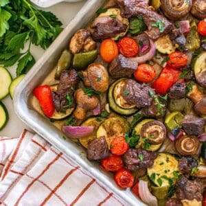 A sheet pan with cooked steak and veggies.