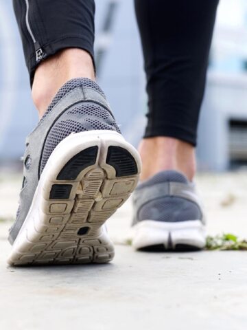 A woman's sneakers walking outside.
