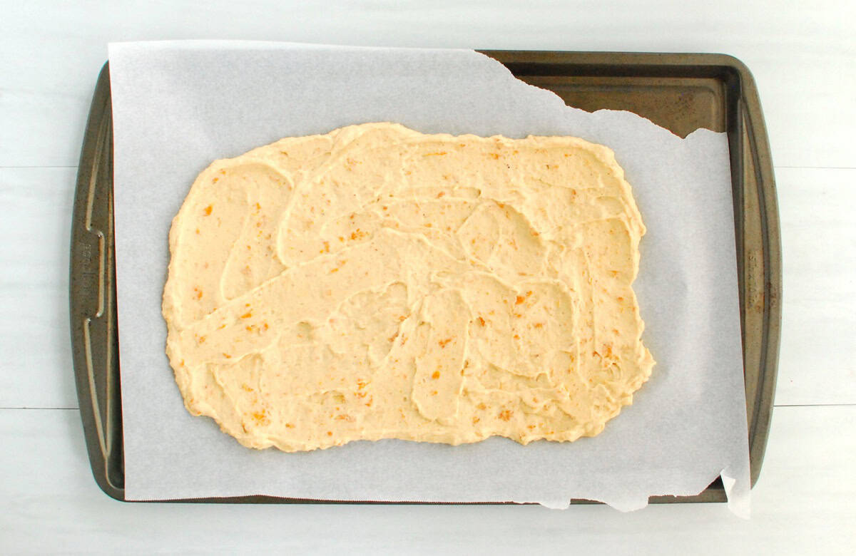 Yogurt mixture spread on a parchment-lined baking sheet.