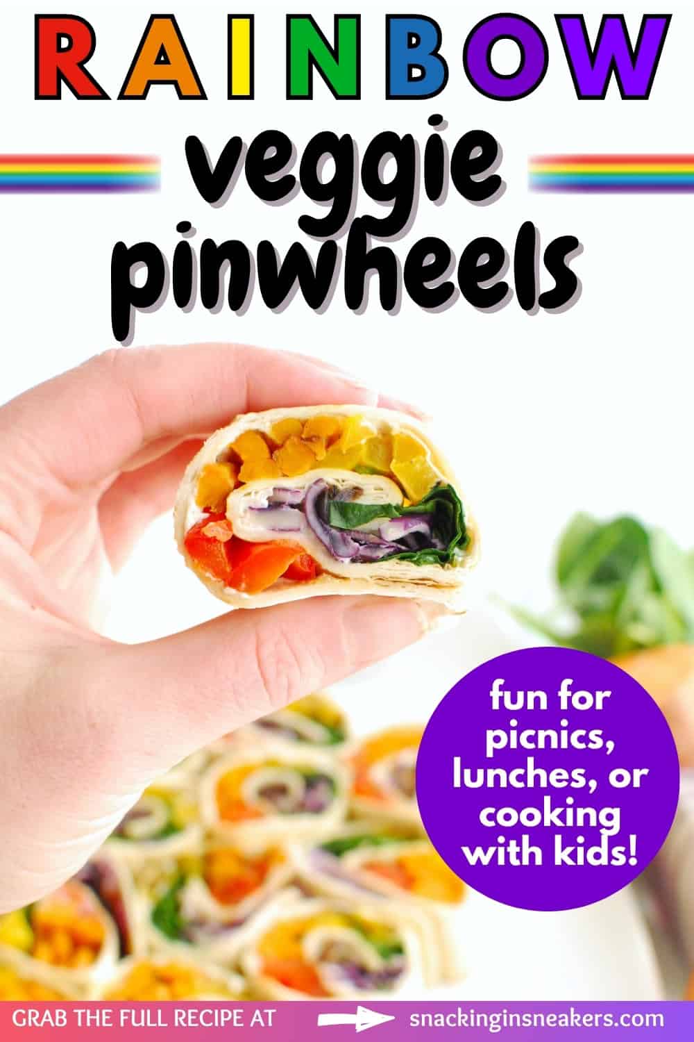 A hand holding a rainbow roasted vegetable pinwheel with a text overlay with the name of the recipe.