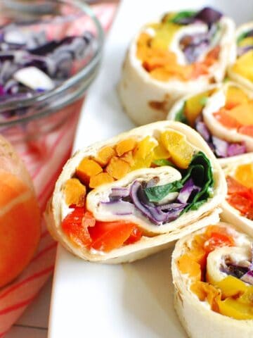 Colorful rainbow veggie pinwheels with fresh vegetables and creamy filling, perfect for healthy snac.